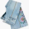 Pantaloni jeans con impunture a fiori